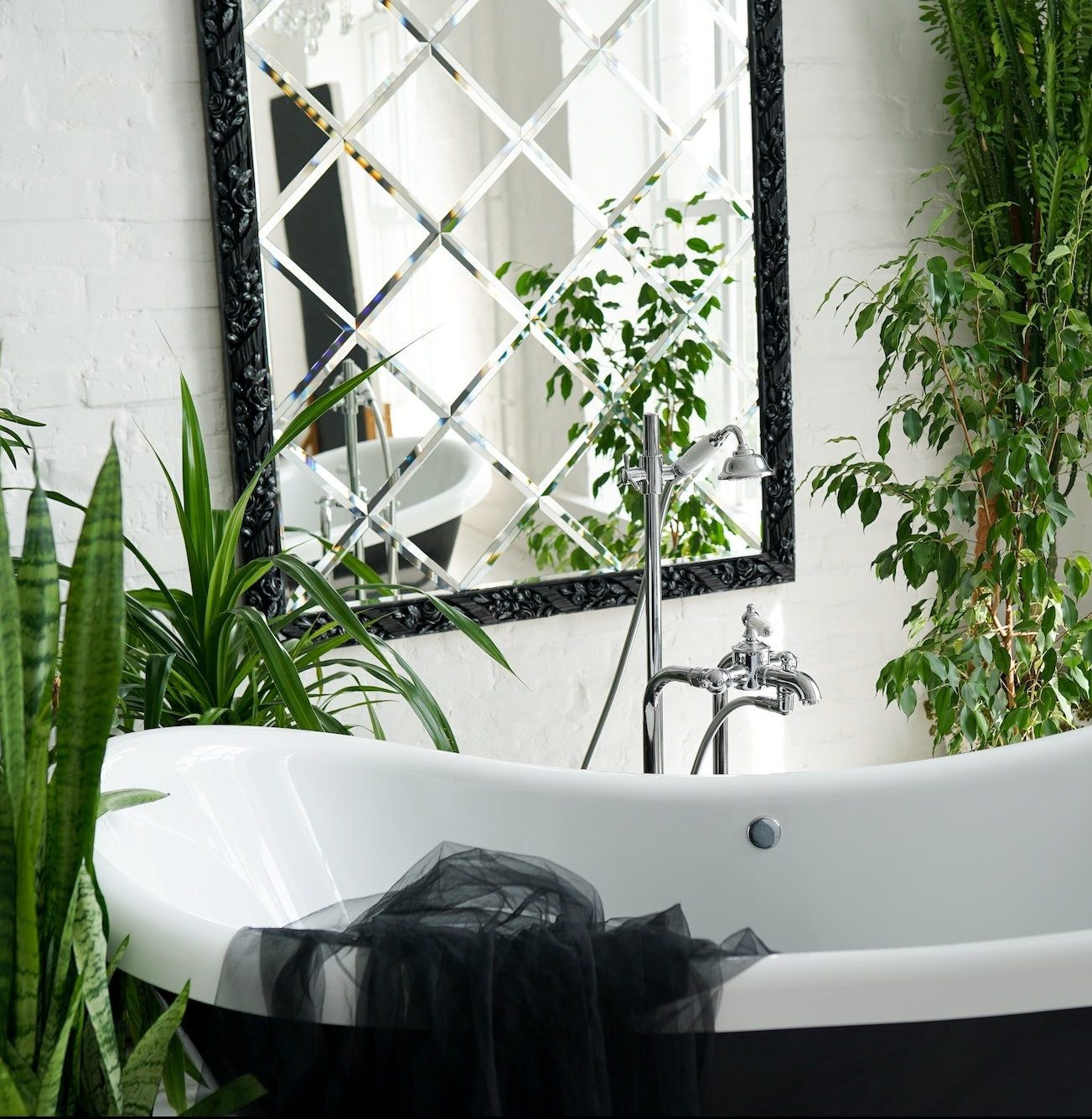 Bathtub and green plants in bathroom interior in luxury home