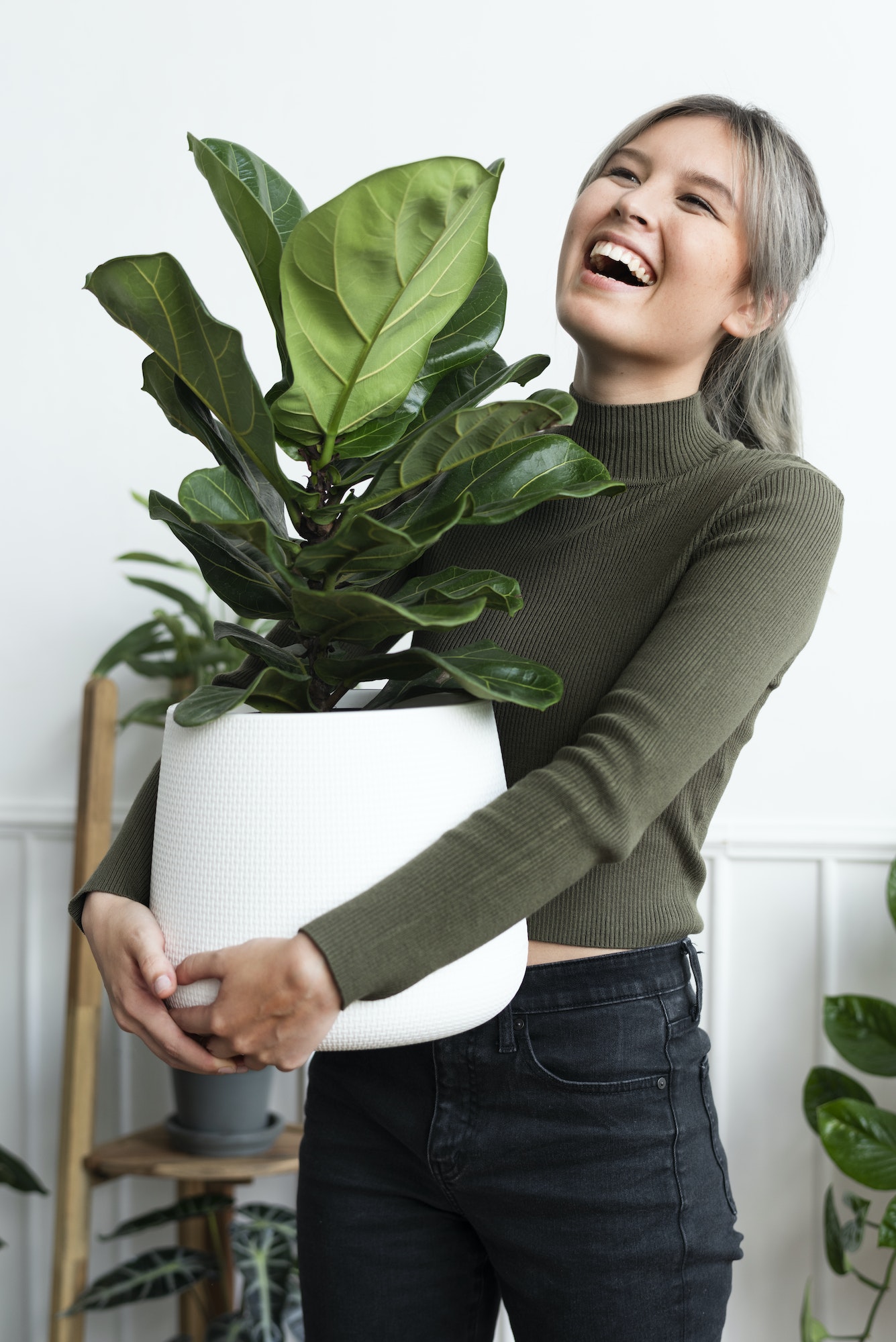 Happy woman carrying a houseplant