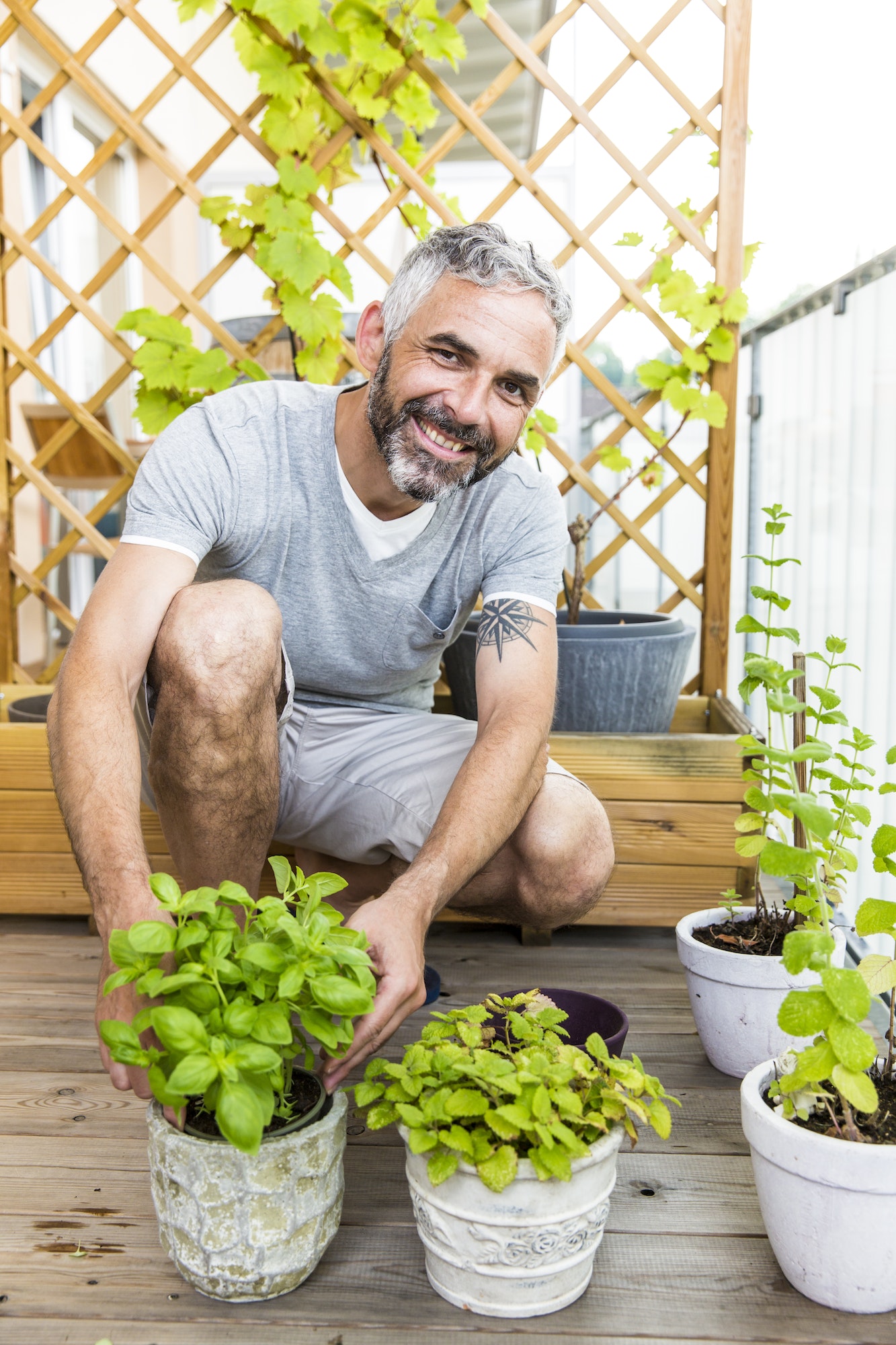 Portrait of smiling man gardening on his balcony