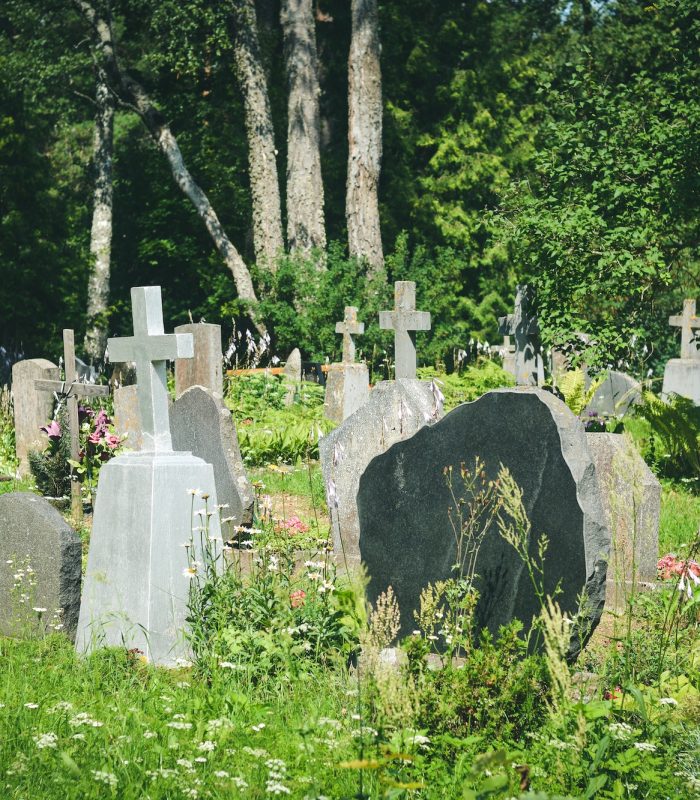 Graves with grave stones at a cemetery in summer. Granite crosses in the cemetery